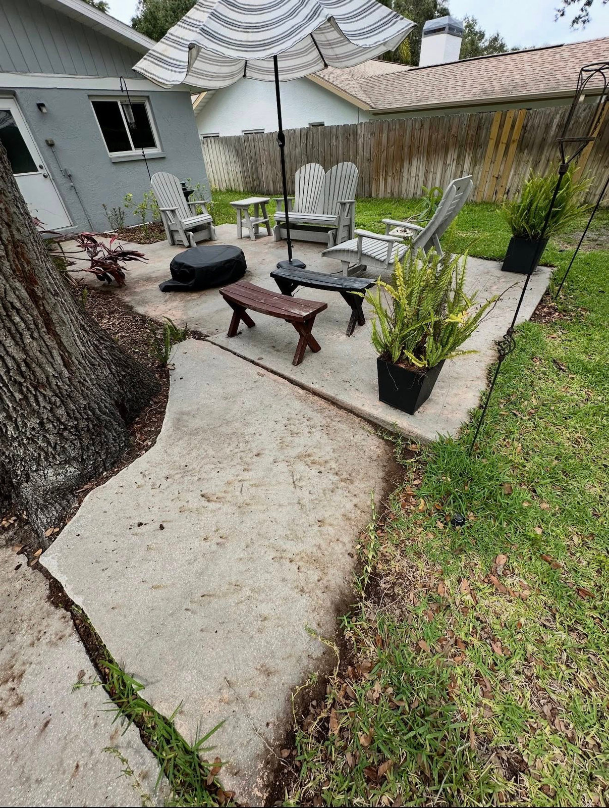 Cracked concrete backyard patio before paver installation
