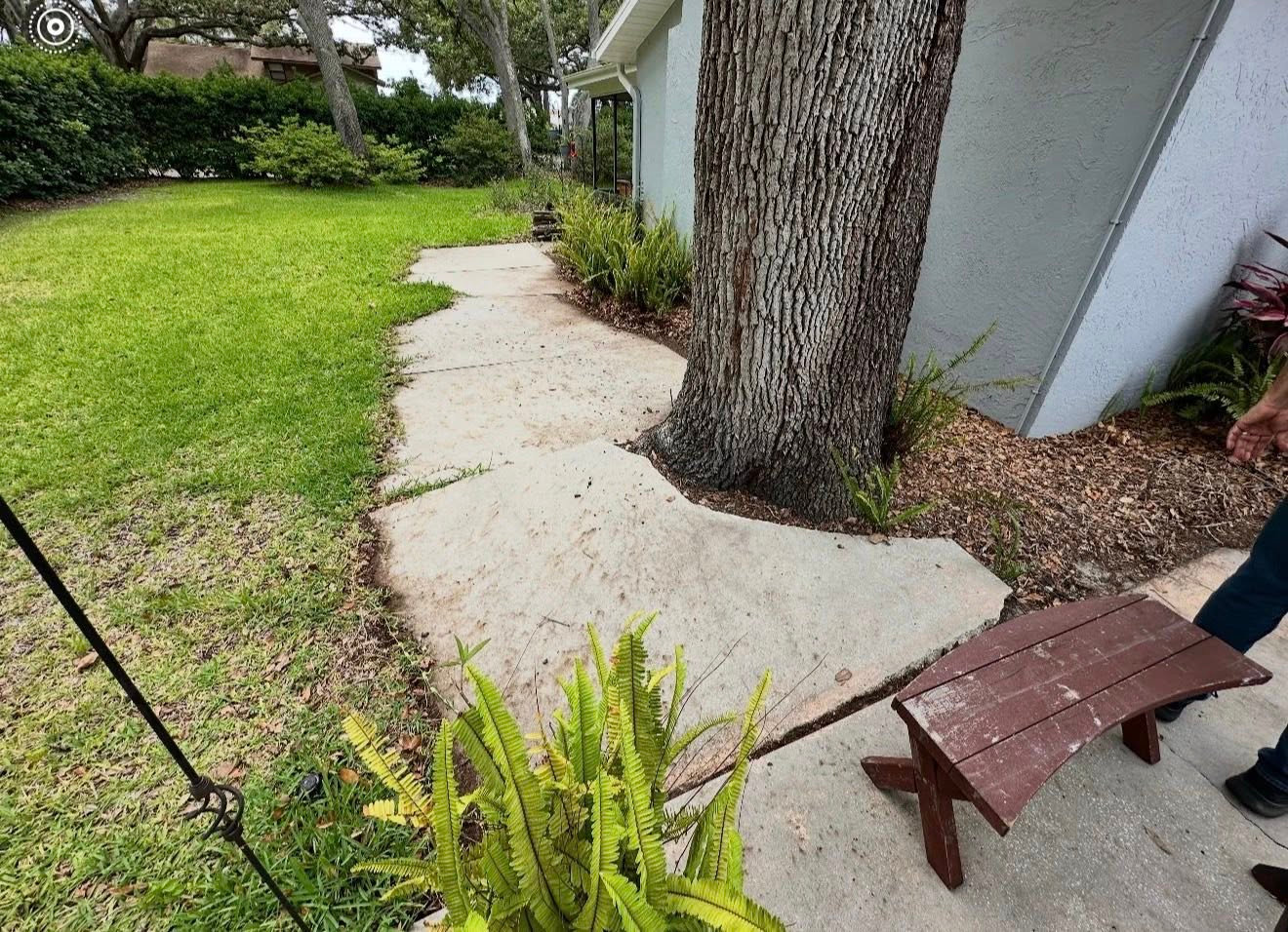 Worn concrete walkway before paver replacement