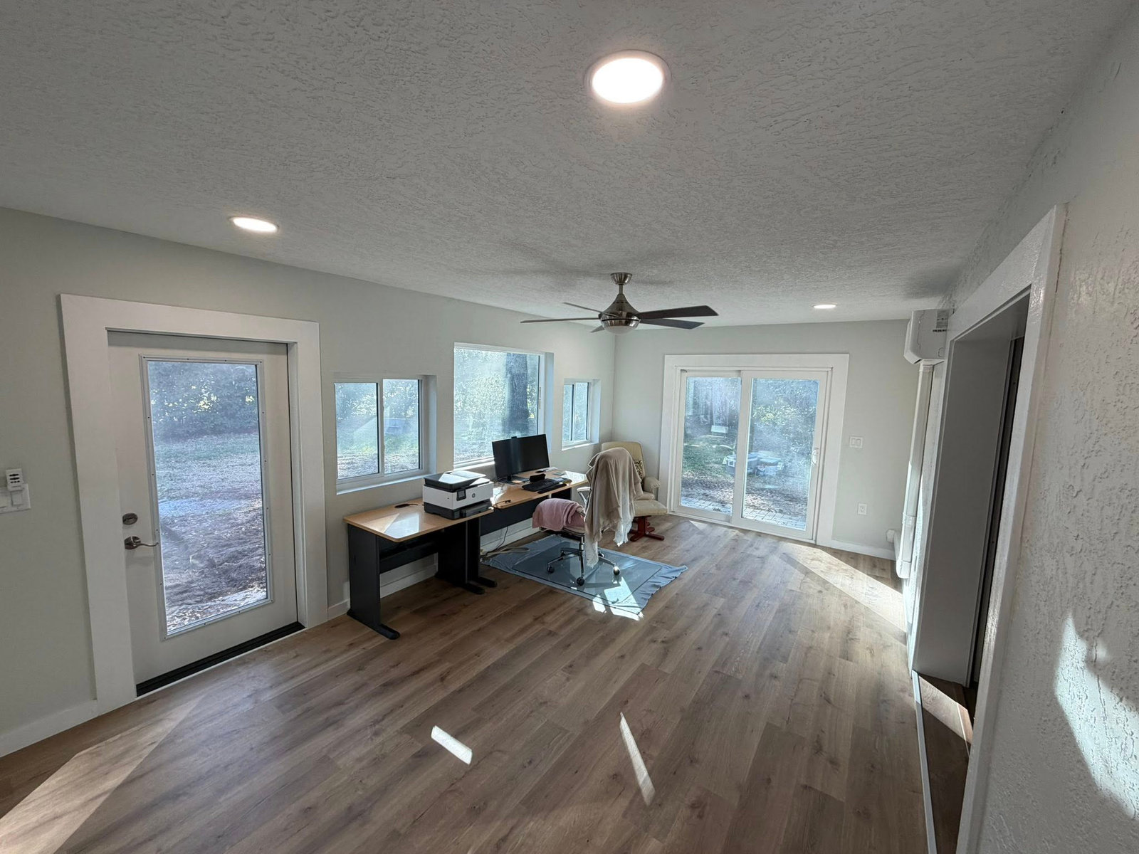 Finished sunroom conversion with new windows, drywall, and luxury vinyl plank flooring